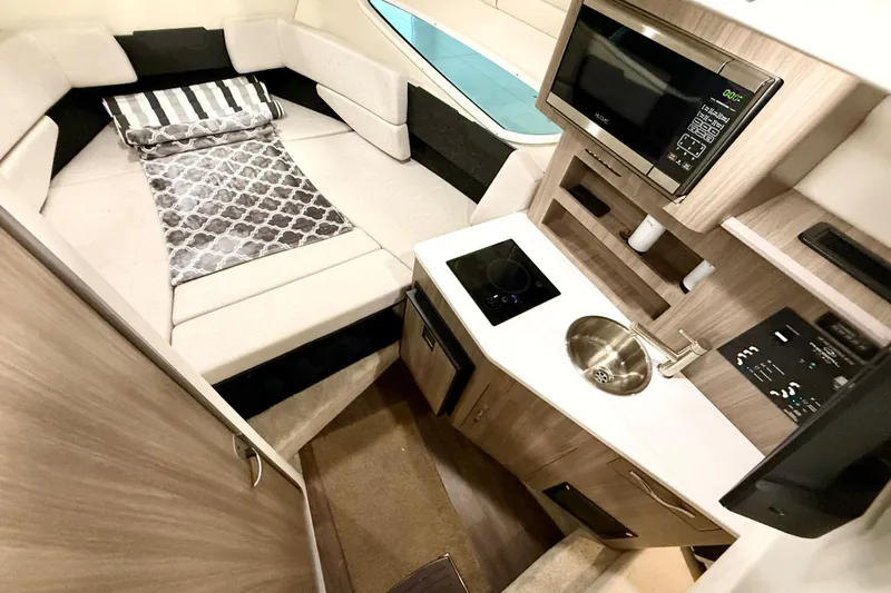 Slide: The Image of 2021 Regal 26 Express cabin interior with kitchenette and cozy sleeping area. - 16