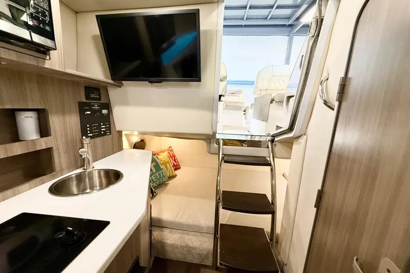 Slide: The Image of Interior of 2021 Regal 26 Express boat with kitchenette and seating area. - 21