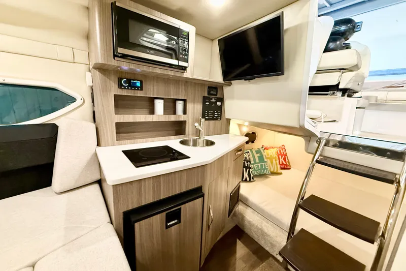 Slide: The Image of Interior of 2021 Regal 26 Express boat with kitchenette, seating, and modern amenities. - 22
