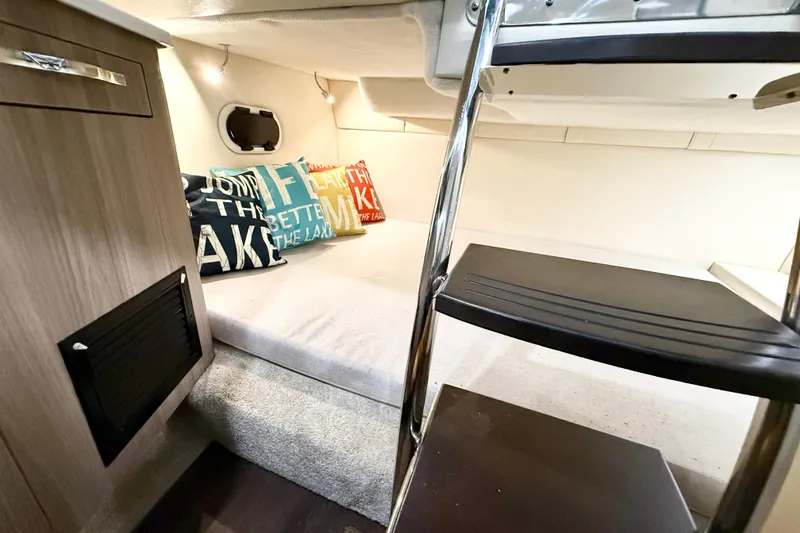 Slide: The Image of Interior cabin of 2021 Regal 26 Express boat with cozy bedding and decorative pillows. - 24