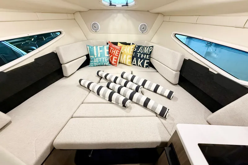 Slide: The Image of 2021 Regal 26 Express cabin interior with cozy seating and decorative pillows. - 25