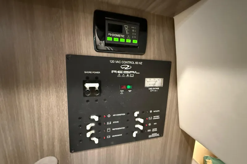 Slide: The Image of Control panel of a 2021 Regal 26 Express boat, featuring various switches and indicators. - 28