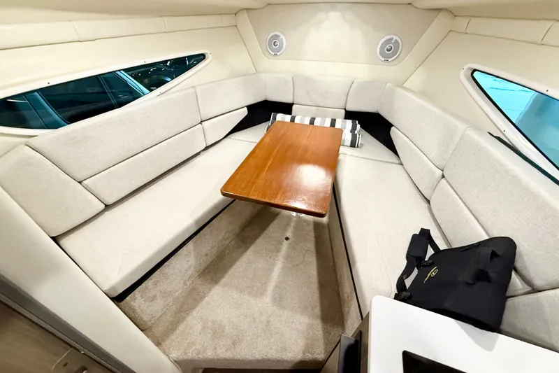Slide: The Image of 2021 Regal 26 Express cabin interior with beige seating and wooden table. - 29