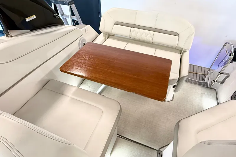 Slide: The Image of Interior of 2021 Regal 26 Express boat with white seating and wooden table. - 30