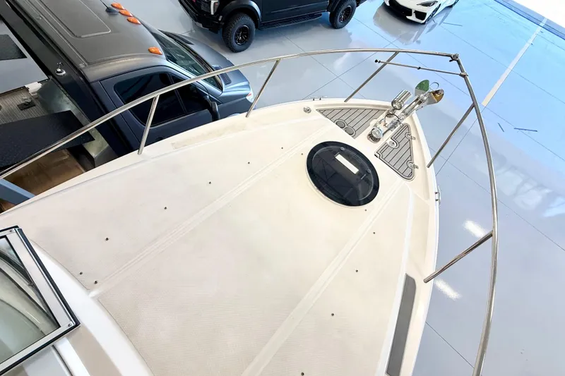 Slide: The Image of 2021 Regal 26 Express boat deck view in a showroom with vehicles nearby. - 35