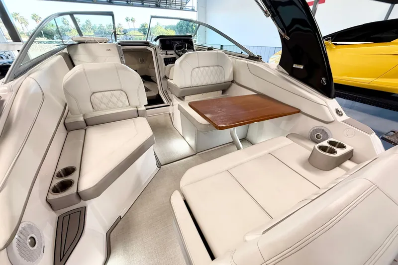Slide: The Image of 2021 Regal 26 Express boat interior with plush seating and wooden table. - 4