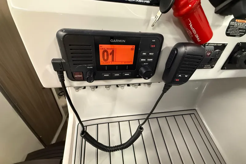 Slide: The Image of Garmin marine radio on 2021 Regal 26 Express boat dashboard with microphone and controls. - 43