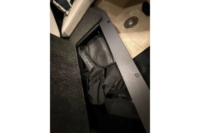 Slide: The Image of Storage compartment in 2021 Regal 26 Express boat, featuring black fabric interior. - 44
