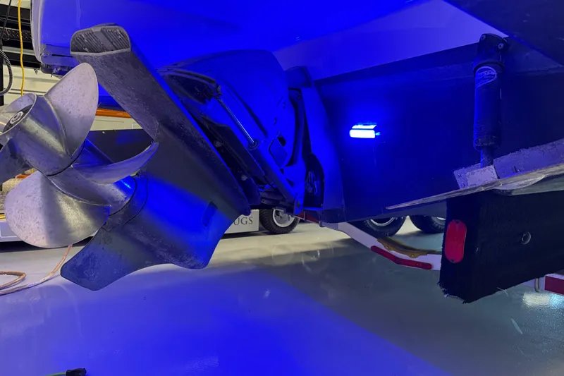 Slide: The Image of 2021 Regal 26 Express boat propeller illuminated by blue light in a garage setting. - 46