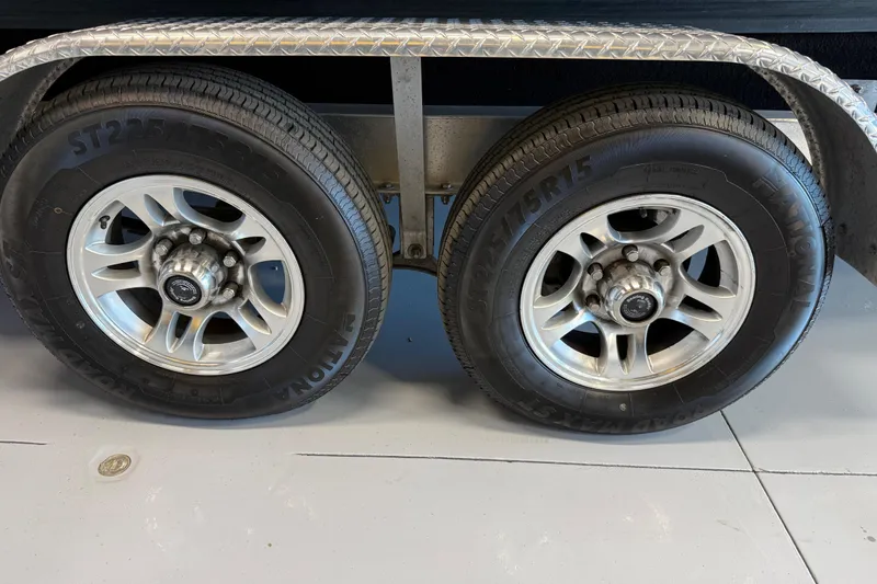 Slide: The Image of Trailer wheels of a 2021 Regal 26 Express boat, featuring alloy rims and ST205/75R15 tires. - 49