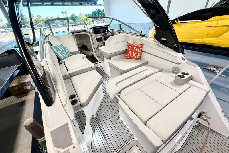 Slide: The Image of Interior of 2021 Regal 26 Express boat with white seating and decorative pillows. - 6