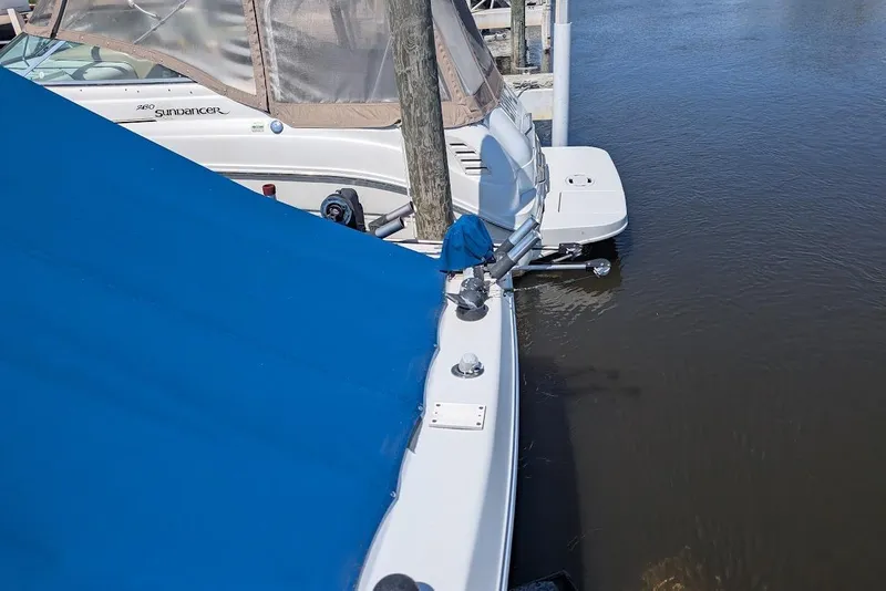 Slide: The Image of 1998 Cherokee 270 Sportsman boat docked with blue cover, adjacent to water. - 11
