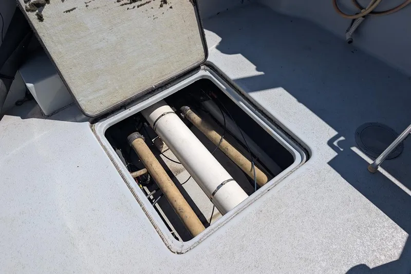 Slide: The Image of Open hatch on 1998 Cherokee 270 Sportsman boat showing internal pipes and components. - 15