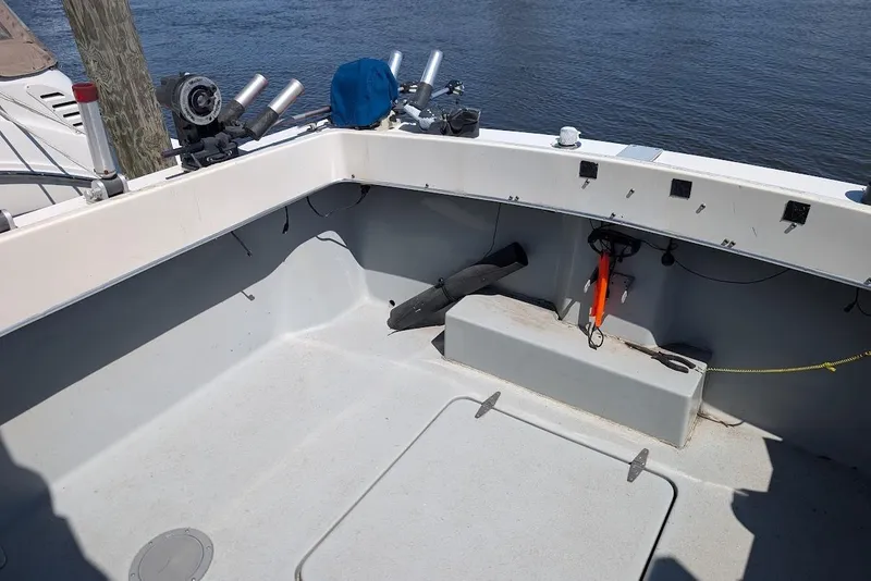 Slide: The Image of 1998 Cherokee 270 Sportsman boat deck with fishing rod holders by the water. - 18