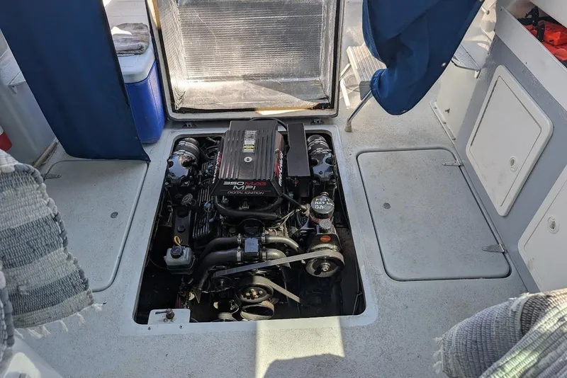 Slide: The Image of Engine compartment of a 1998 Cherokee 270 Sportsman boat, showcasing the motor. - 26