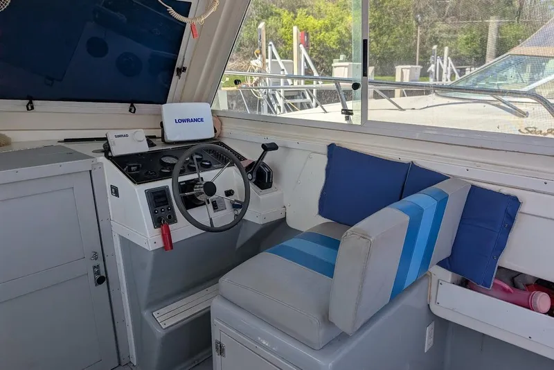 Slide: The Image of 1998 Cherokee 270 Sportsman boat cockpit with steering wheel, navigation equipment, and cushioned seating. - 31