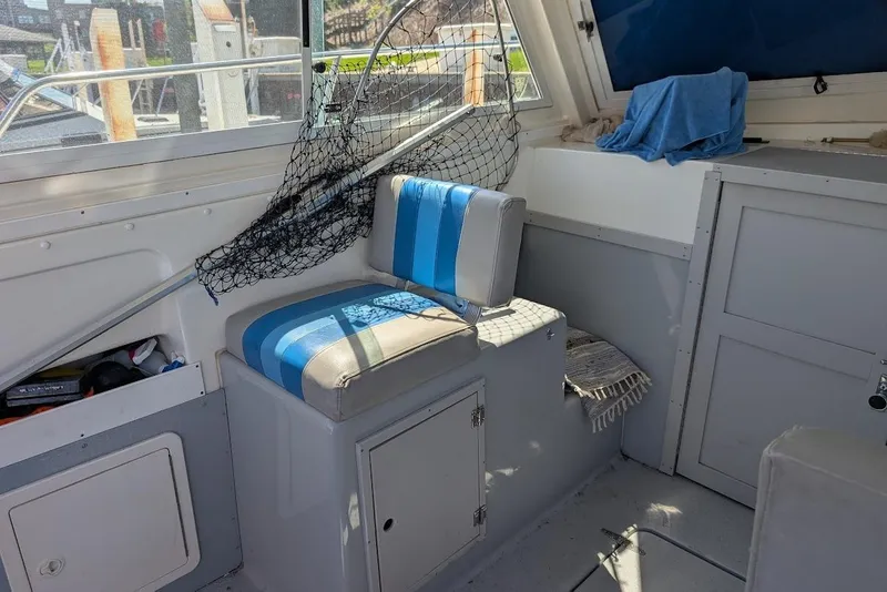 Slide: The Image of Interior of a 1998 Cherokee 270 Sportsman boat with seating and fishing net. - 32