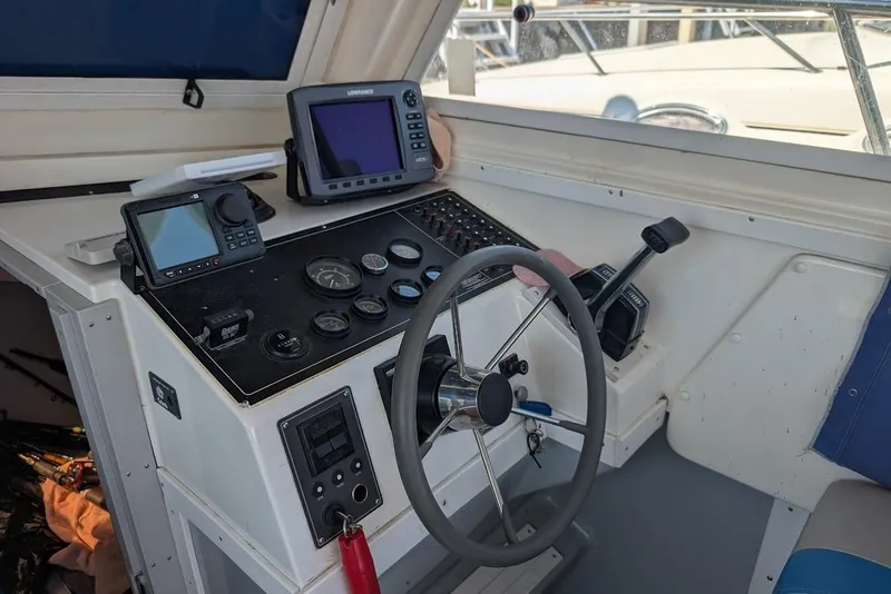 Slide: The Image of Cockpit of a 1998 Cherokee 270 Sportsman boat with navigation instruments and steering wheel. - 37