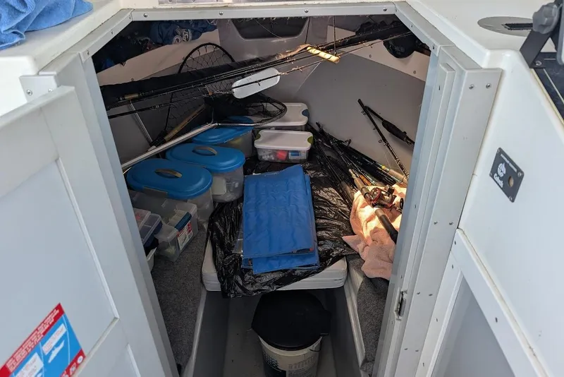 Slide: The Image of Interior of a 1998 Cherokee 270 Sportsman boat with fishing gear and storage containers. - 41