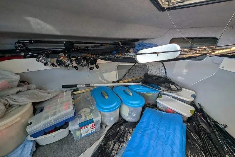 Slide: The Image of Interior of a 1998 Cherokee 270 Sportsman boat with fishing gear and storage containers. - 42