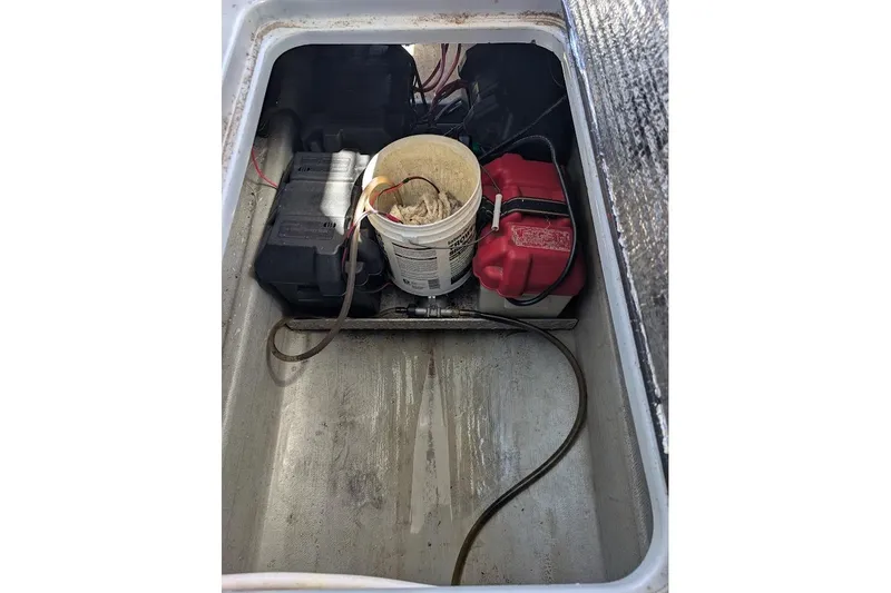 Slide: The Image of Battery compartment of a 1998 Cherokee 270 Sportsman boat with wiring and a bucket. - 43