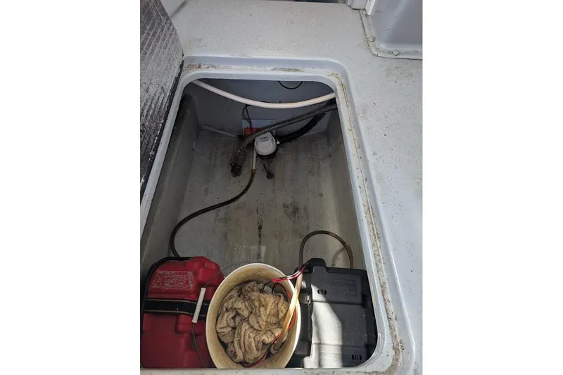 Slide: The Image of 1998 Cherokee 270 Sportsman boat compartment with battery and maintenance tools. - 44