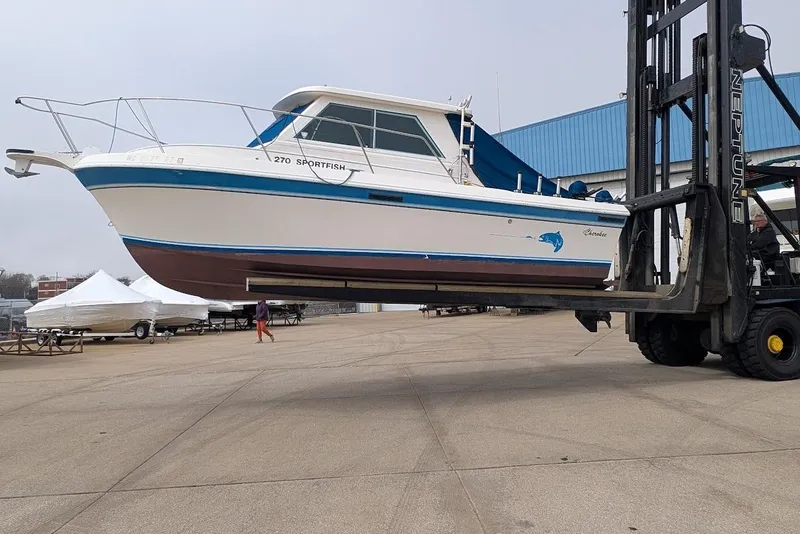 Slide: The Image of 1998 Cherokee 270 Sportsman boat lifted by forklift at marina. - 47