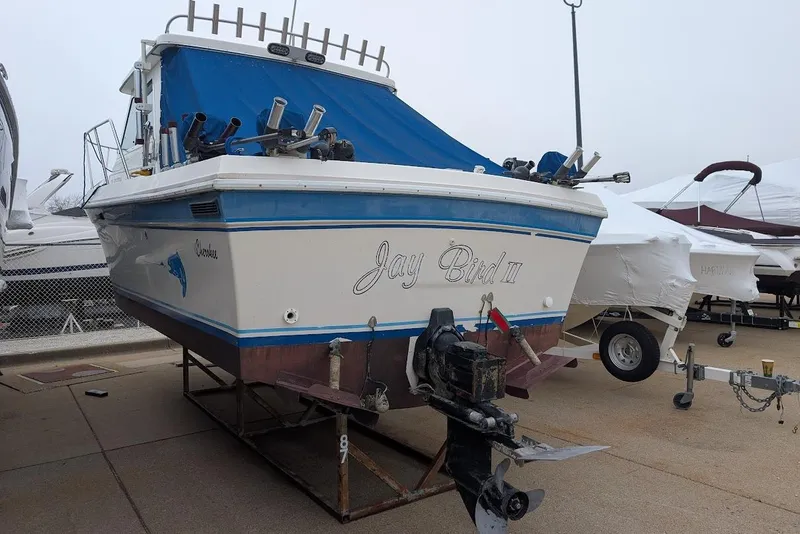 Slide: The Image of 1998 Cherokee 270 Sportsman boat, named "Jay Bird III," docked with blue cover. - 49
