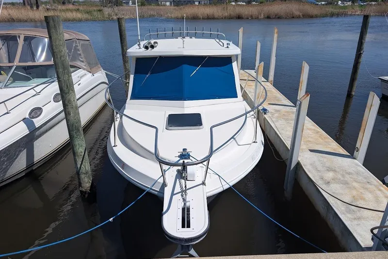 Slide: The Image of 1998 Cherokee 270 Sportsman boat docked at marina, front view. - 6