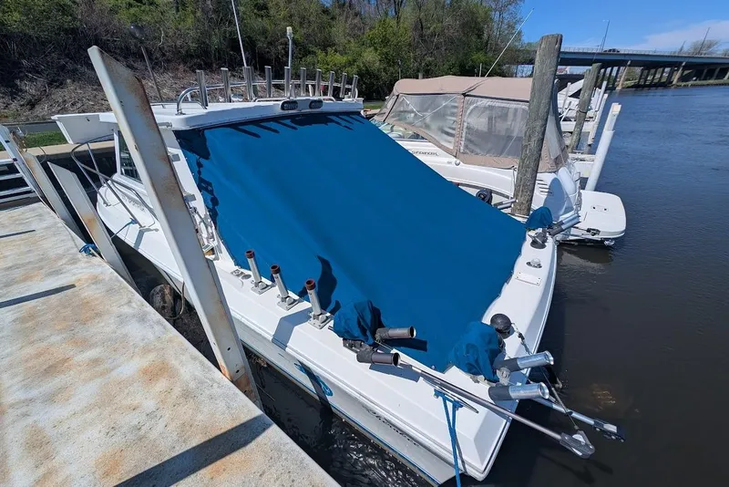 Slide: The Image of 1998 Cherokee 270 Sportsman boat docked with blue cover, fishing rods visible. - 9