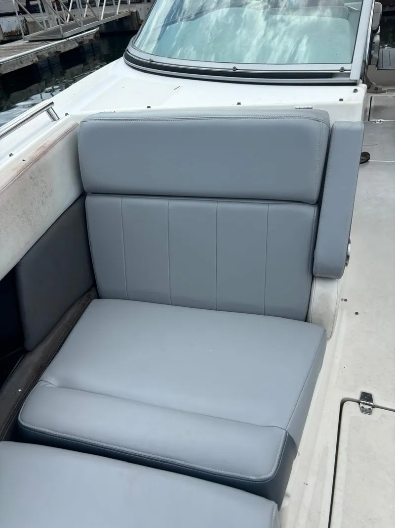 Slide: The Image of 2013 Regal 3200 Bowrider boat with gray seating, docked at marina. - 10