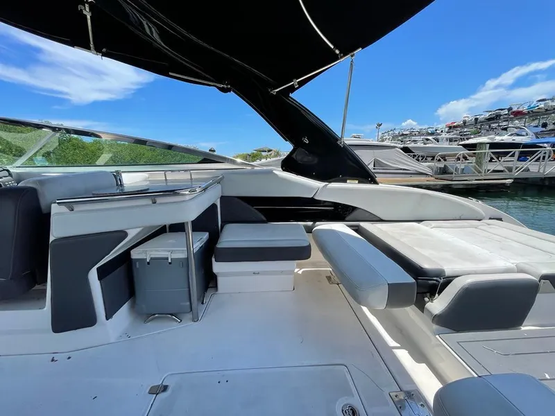 Slide: The Image of 2013 Regal 3200 Bowrider interior with seating, under a sunny sky at the marina. - 9