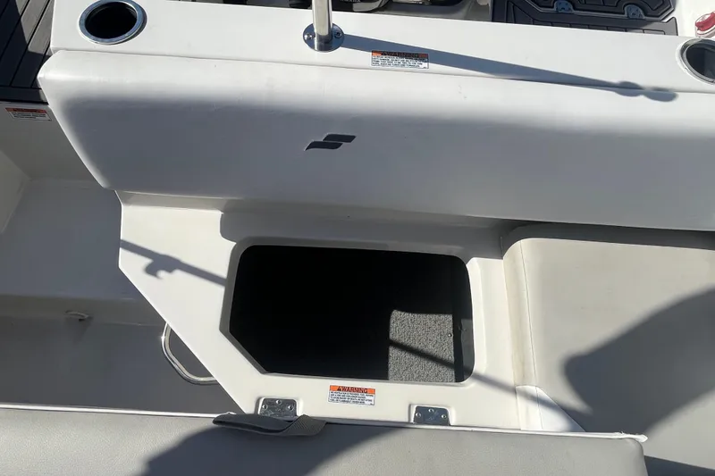 Slide: The Image of 2025 Starcraft SVX 171 OB boat interior with storage compartment and cup holders. - 18