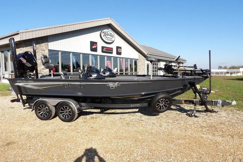 The Image of 2026 Lund 2075 Pro-V Bass XS boat on trailer outside dealership. - 1