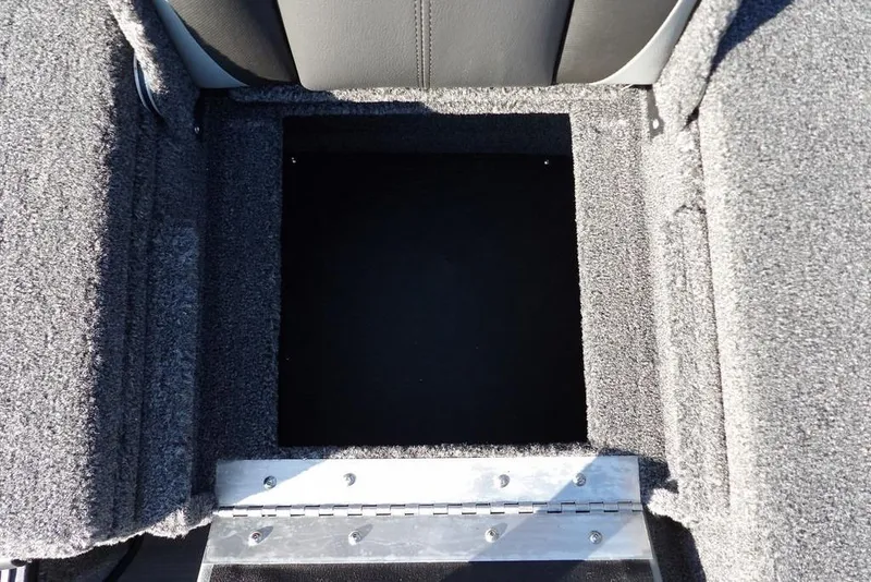 Slide: The Image of 2026 Lund 2075 Pro-V Bass XS boat storage compartment with gray carpeted interior. - 11