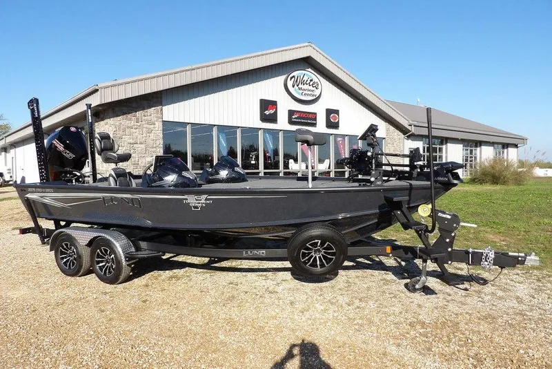 Slide: The Image of 2026 Lund 2075 Pro-V Bass XS boat parked outside a marine center. - 17