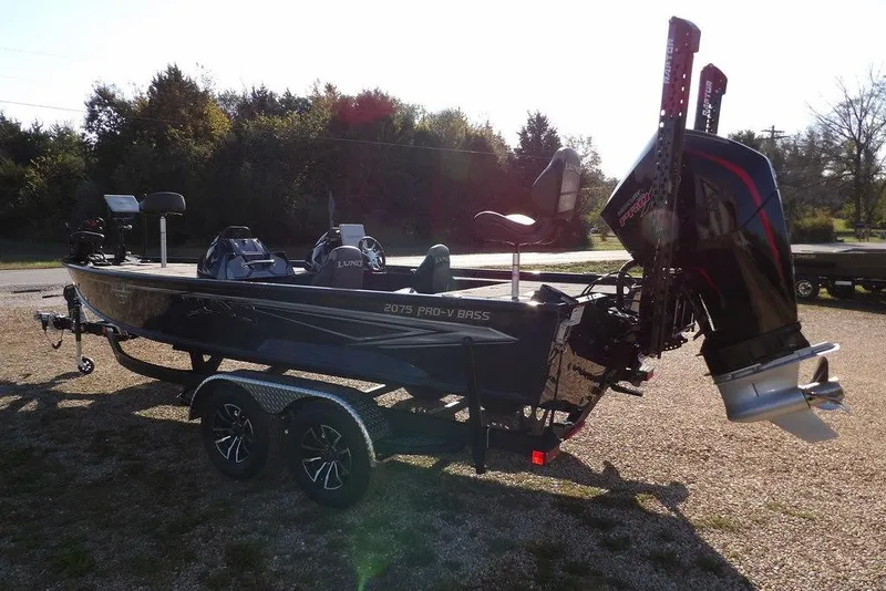 Slide: The Image of 2026 Lund 2075 Pro-V Bass XS boat on trailer, parked outdoors. - 22