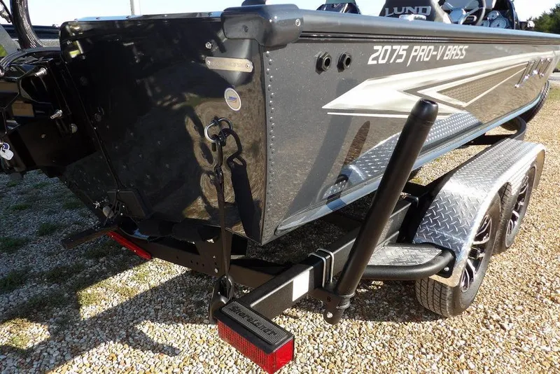 Slide: The Image of 2026 Lund 2075 Pro-V Bass XS boat on trailer, featuring sleek design and dual axles. - 26
