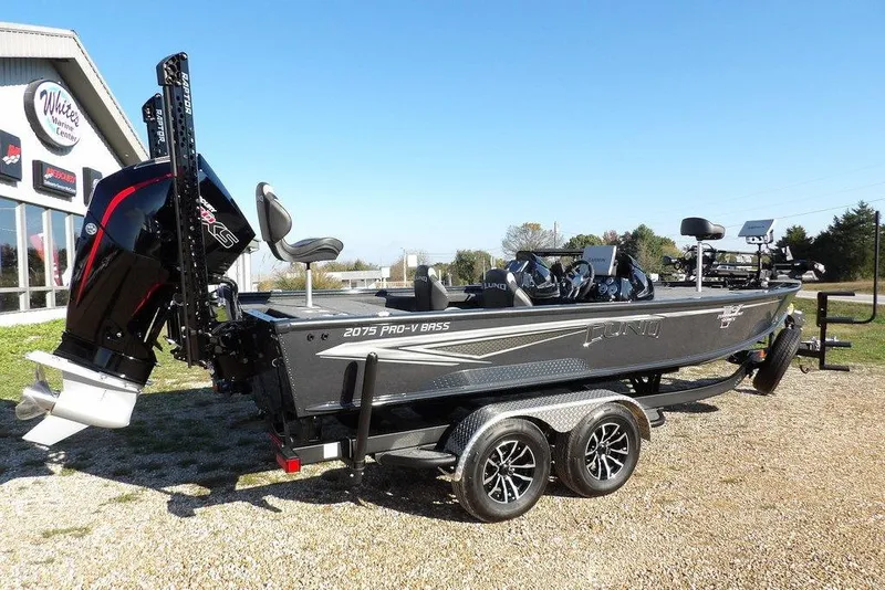 Slide: The Image of 2026 Lund 2075 Pro-V Bass XS boat on trailer, parked outdoors. - 3