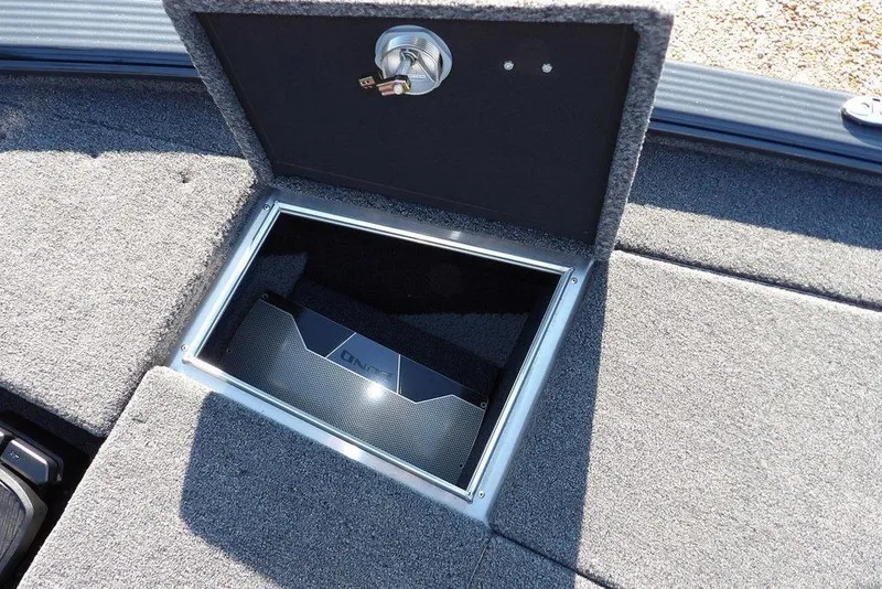 Slide: The Image of Storage compartment in 2026 Lund 2075 Pro-V Bass XS boat, featuring secure lock and carpeted interior. - 38