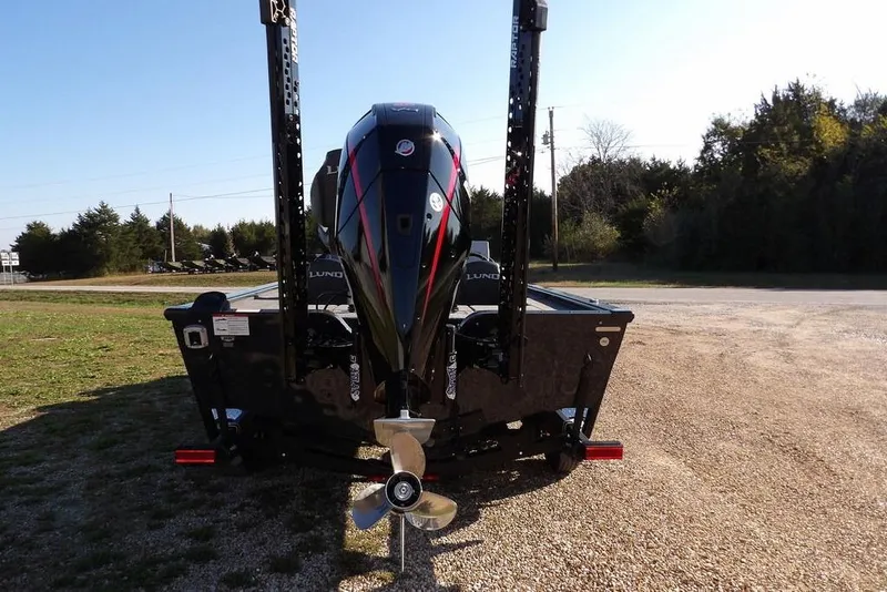 Slide: The Image of 2026 Lund 2075 Pro-V Bass XS boat with powerful outboard motor, parked on gravel. - 71