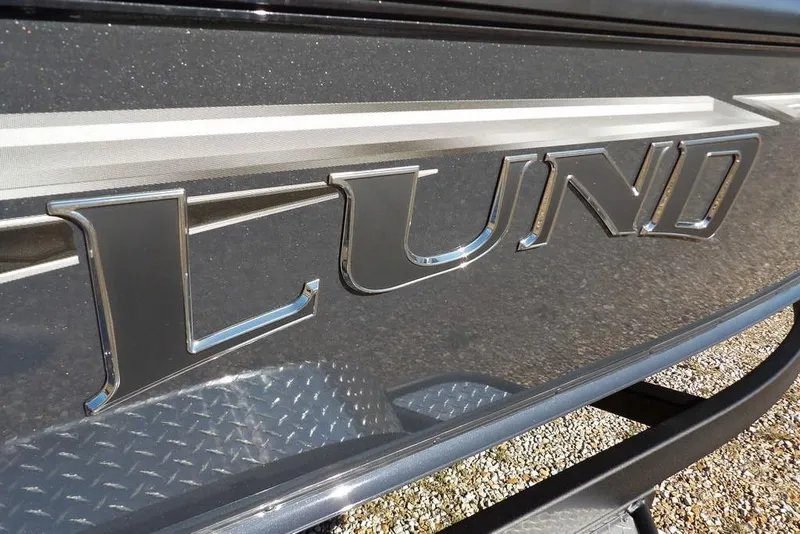 Slide: The Image of Close-up of 2026 Lund 2075 Pro-V Bass XS boat logo on metallic surface. - 79