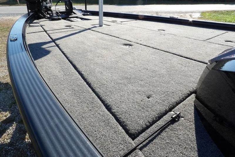 Slide: The Image of 2026 Lund 2075 Pro-V Bass XS boat deck with carpeted surface and storage compartments. - 8