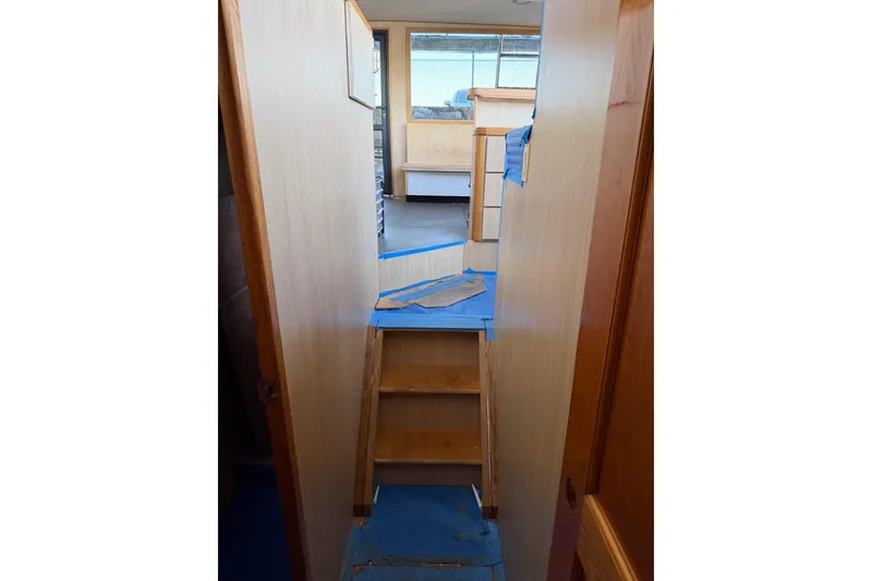 Slide: The Image of Interior view of 1990 Chris-Craft 392 Commander yacht, featuring wooden stairs and cabin area. - 10