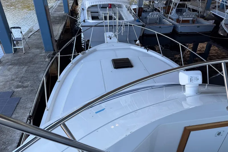Slide: The Image of 1990 Chris-Craft 392 Commander yacht docked, showcasing sleek design and spacious deck. - 17