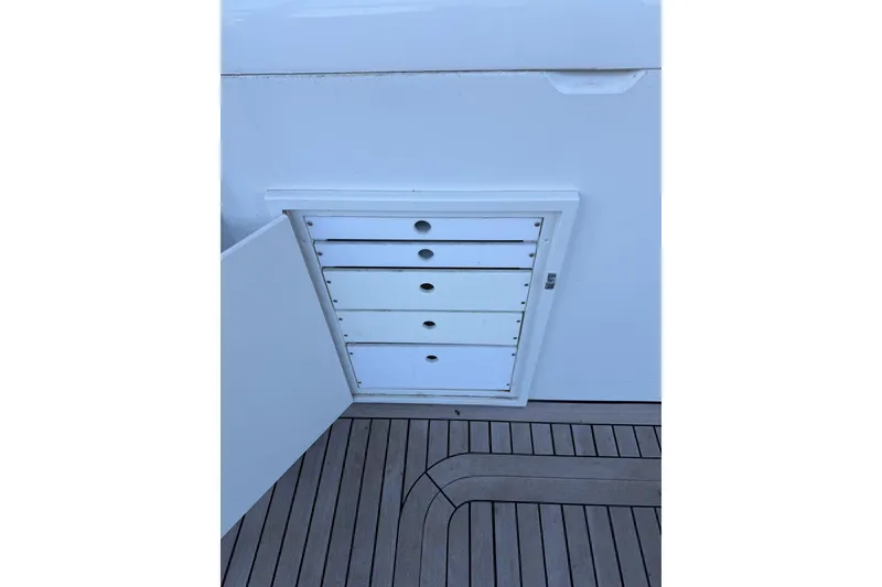 Slide: The Image of Storage drawers on 1990 Chris-Craft 392 Commander boat, featuring white cabinetry and wooden deck. - 20