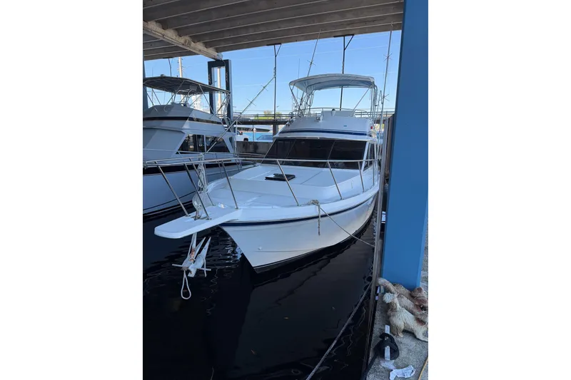 Slide: The Image of 1990 Chris-Craft 392 Commander yacht docked under a covered marina. - 26