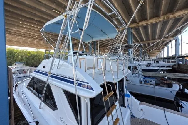 Slide: The Image of 1990 Chris-Craft 392 Commander yacht docked under a covered marina. - 27