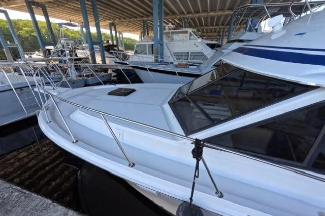 Slide: The Image of 1990 Chris-Craft 392 Commander yacht docked in a marina under a covered structure. - 28
