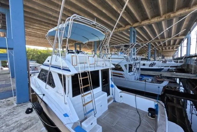 Slide: The Image of 1990 Chris-Craft 392 Commander yacht docked under a covered marina. - 29